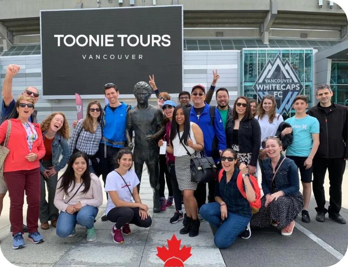 A group of people posing in front of a sign that says tonie tours vancouver.
