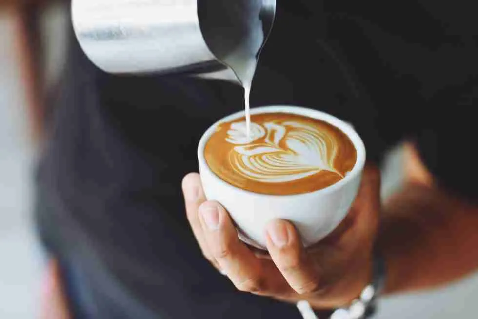 A person pouring coffee into a cup.