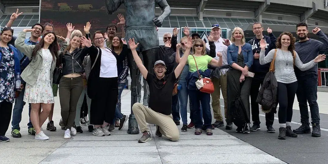 A group of people posing in front of a statue.
